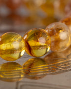 Detalle macro de las cuentas de Ámbar de la pulsera Sol Invictus con luz calida