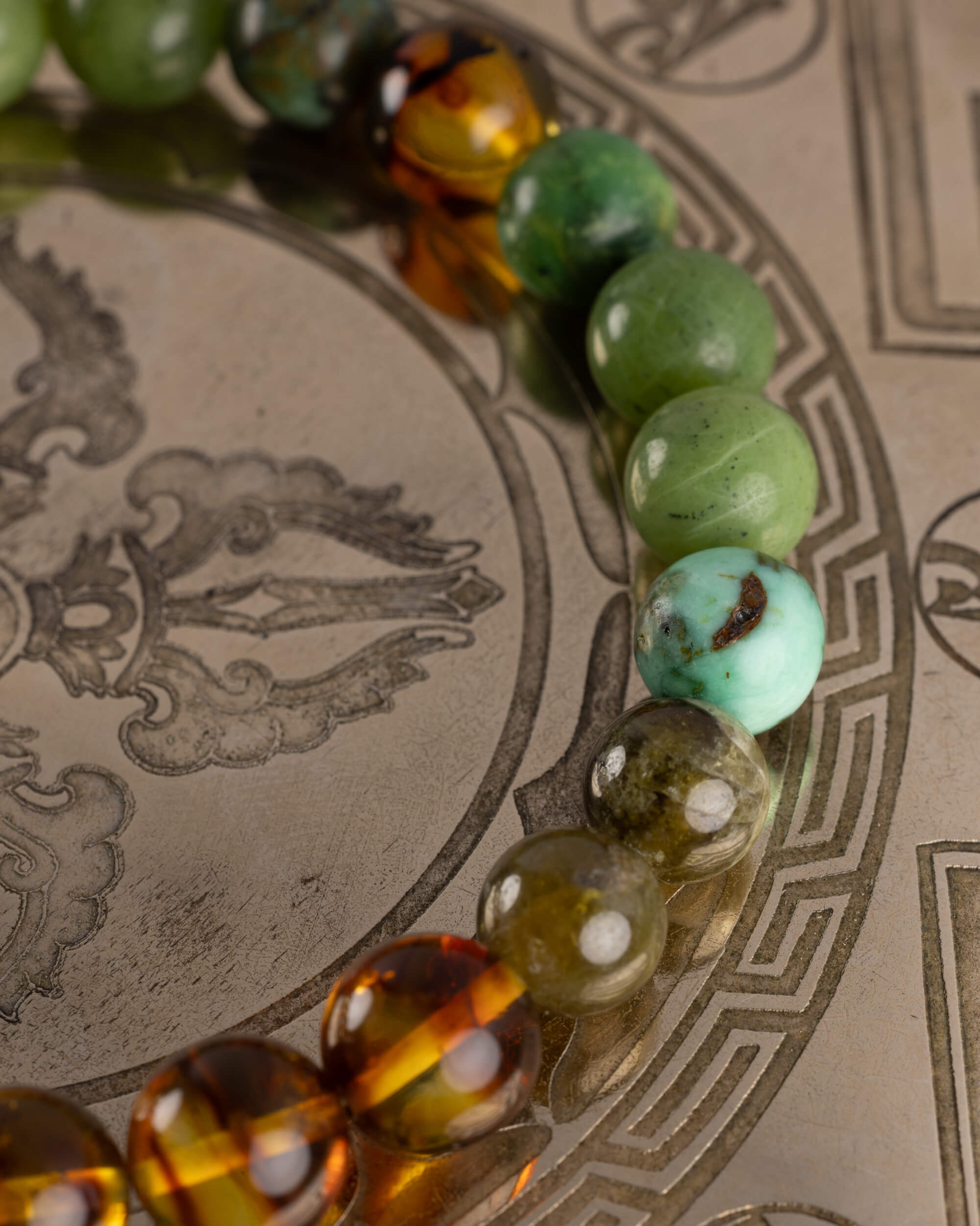 Detalle macro de las cuentas de Jade Verde, Turquesa y Ámbar de la pulsera Usil