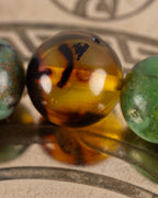 Detalle macro de una cuenta de Ámbar entre Jade Verde y Turquesa de la pulsera Usil