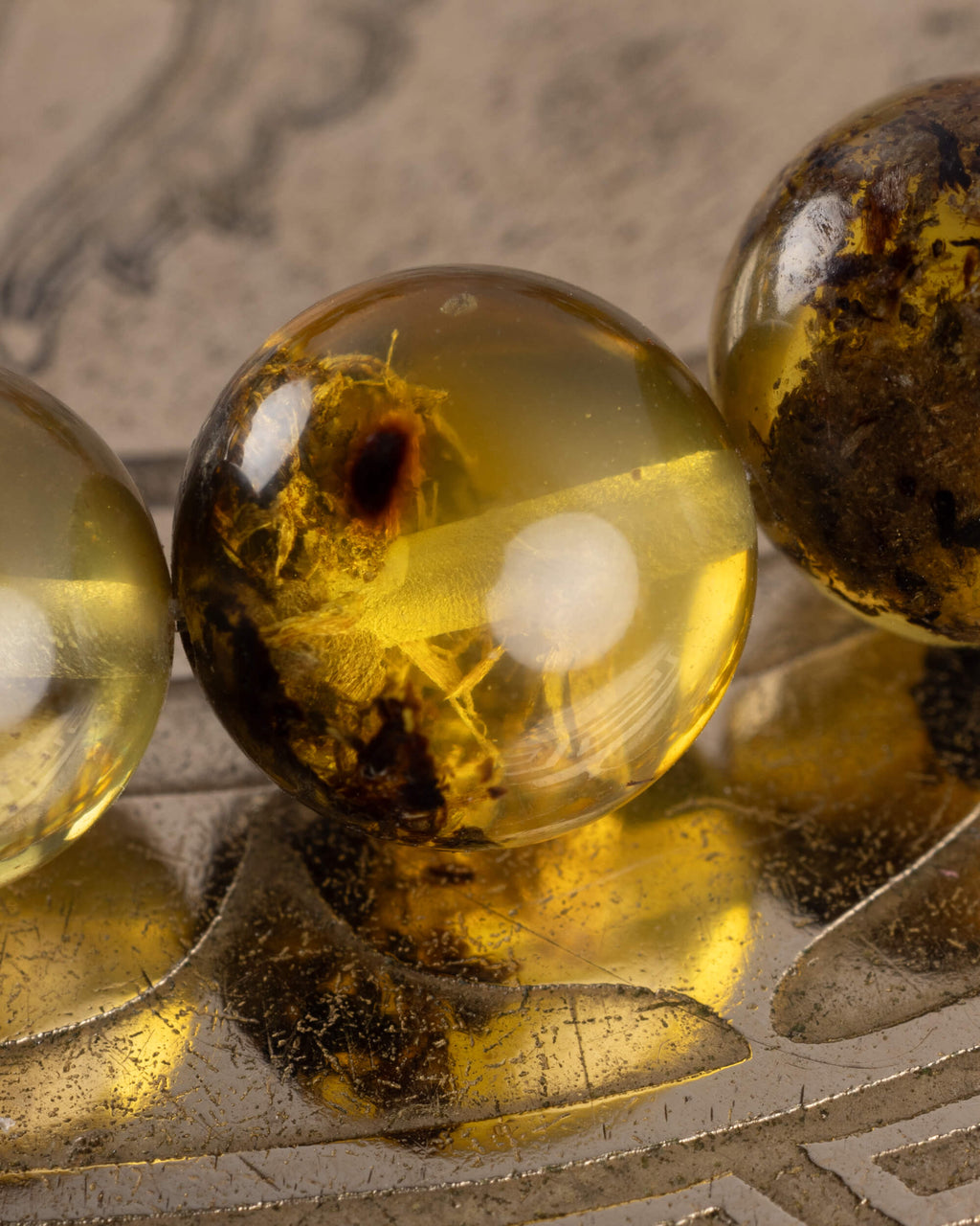 Detalle macro de una cuenta de Ámbar con inclusiones naturales de la pulsera Saule