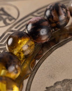Detalle macro de las cuentas de Rodonita Encaje Negro y Ámbar de la pulsera Saule