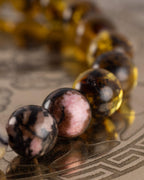 Detalle macro de las cuentas de Rodonita Encaje Negro y Ámbar de la pulsera Saule