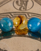 Detalle macro de las cuentas de Apatita Azul y Ámbar de la pulsera Tamanuiterā