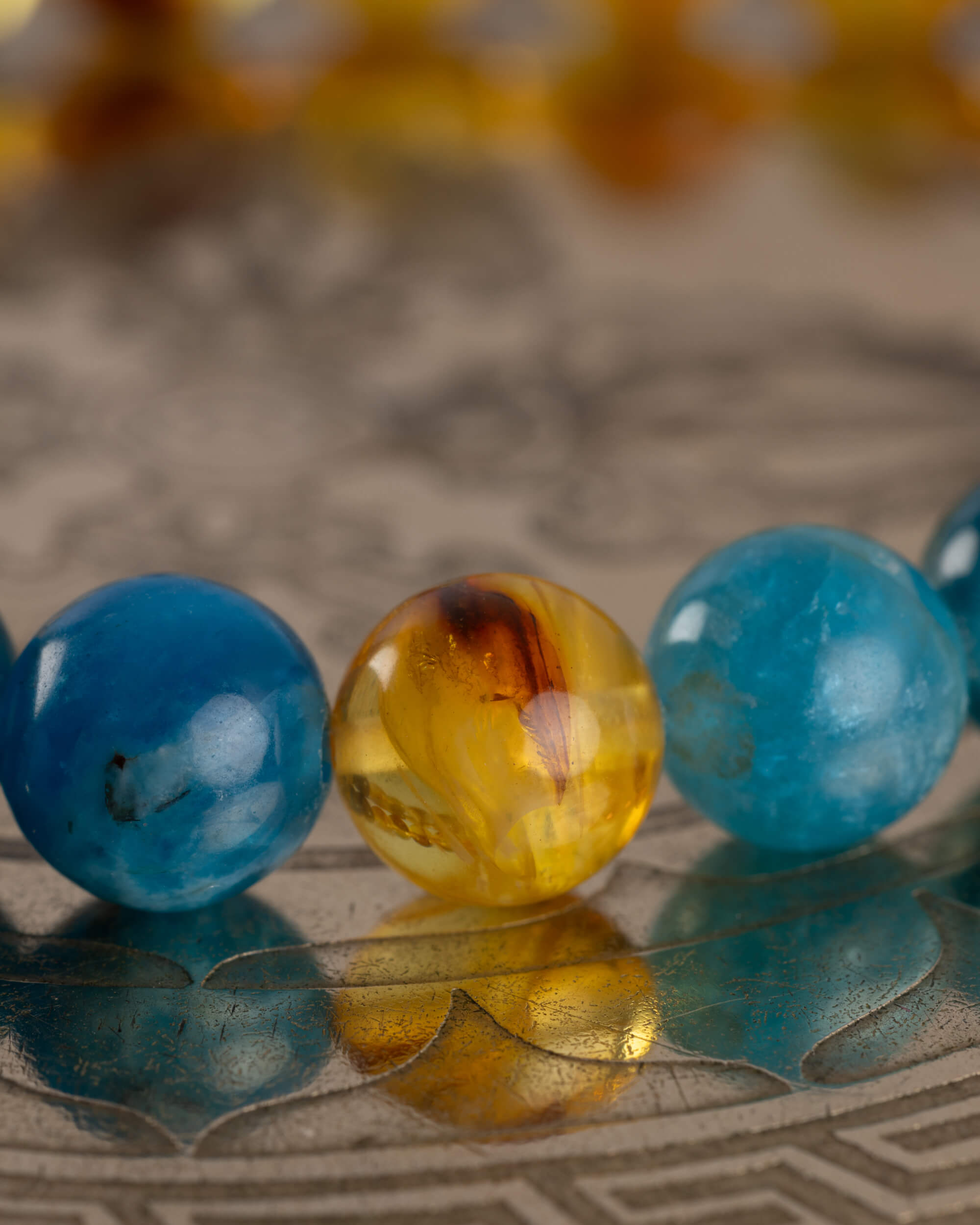 Detalle macro de la union entre cuentas de Apatita Azul y Ámbar de la pulsera