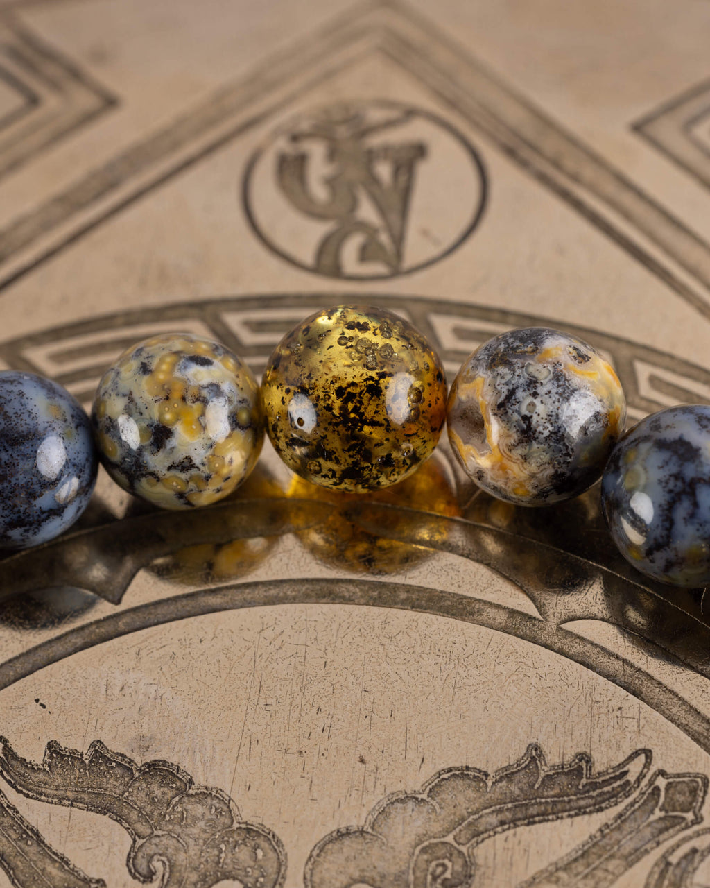 Detalle macro de cuentas de Ámbar en foco con Turquesa Africana y Lapislázuli desenfocadas, Pulsera Utu
