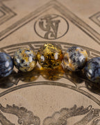 Detalle macro de cuentas de Ámbar en foco con Turquesa Africana y Lapislázuli desenfocadas, Pulsera Utu