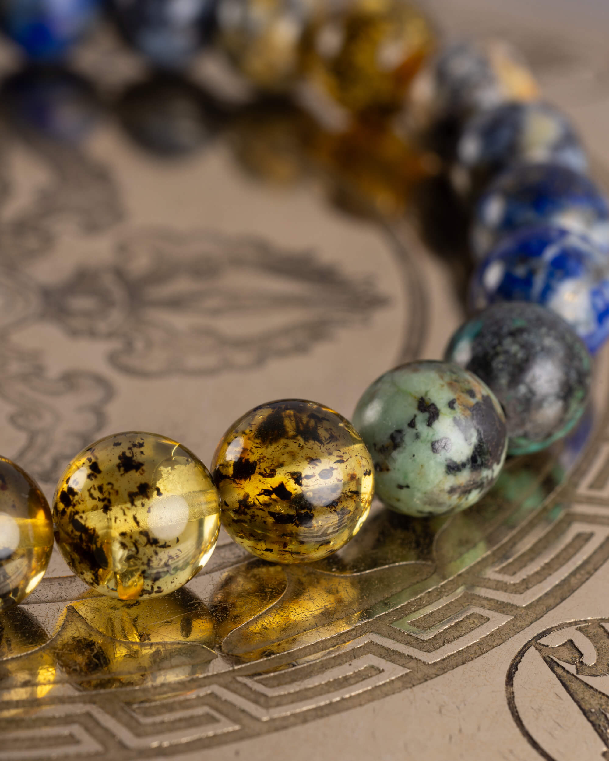 Detalle macro de las cuentas de Ámbar, Turquesa Africana y Lapislázuli de la Pulsera Utu