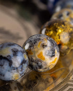 Detalle macro de las cuentas de Jaspe Oceánico y Ámbar de la Pulsera Utu sobre placa grabada
