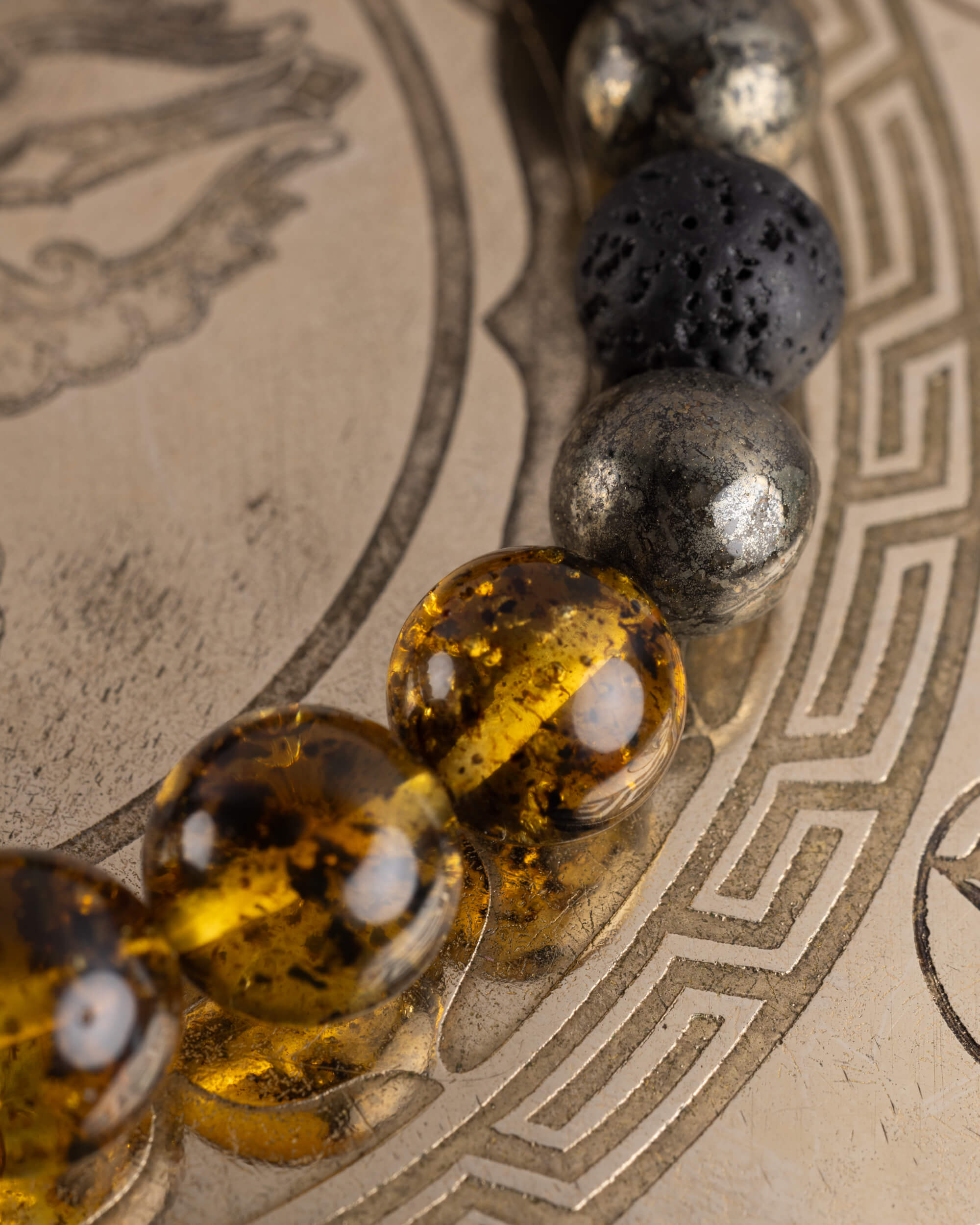 Detalle macro de las cuentas de Ámbar, Pirita y Piedra Volcánica de la Pulsera Malakbel
