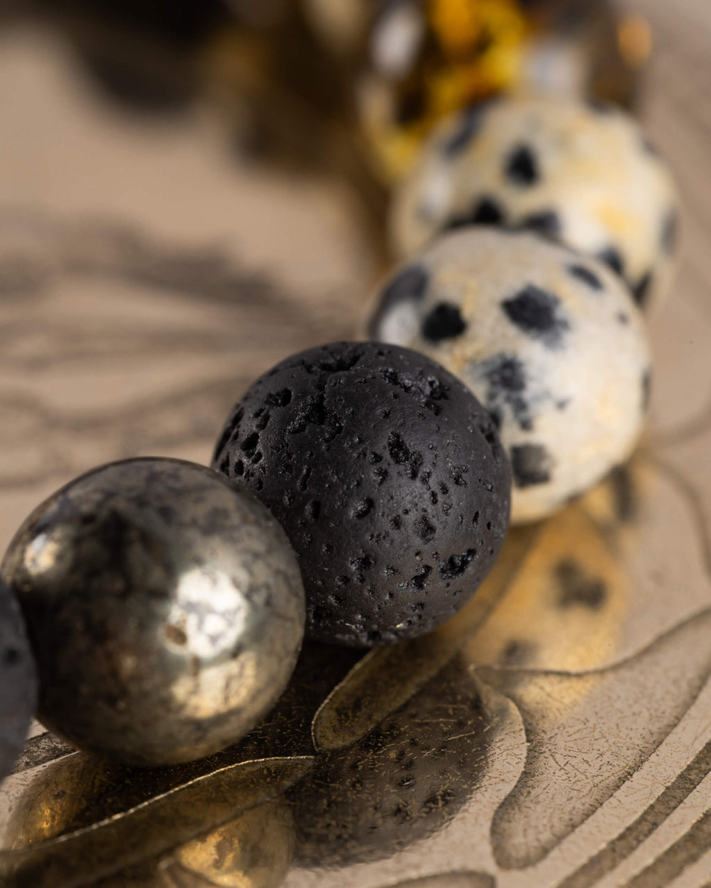 Detalle macro de las cuentas de Piedra Volcánica y Jaspe Dálmata de la Pulsera Malakbel