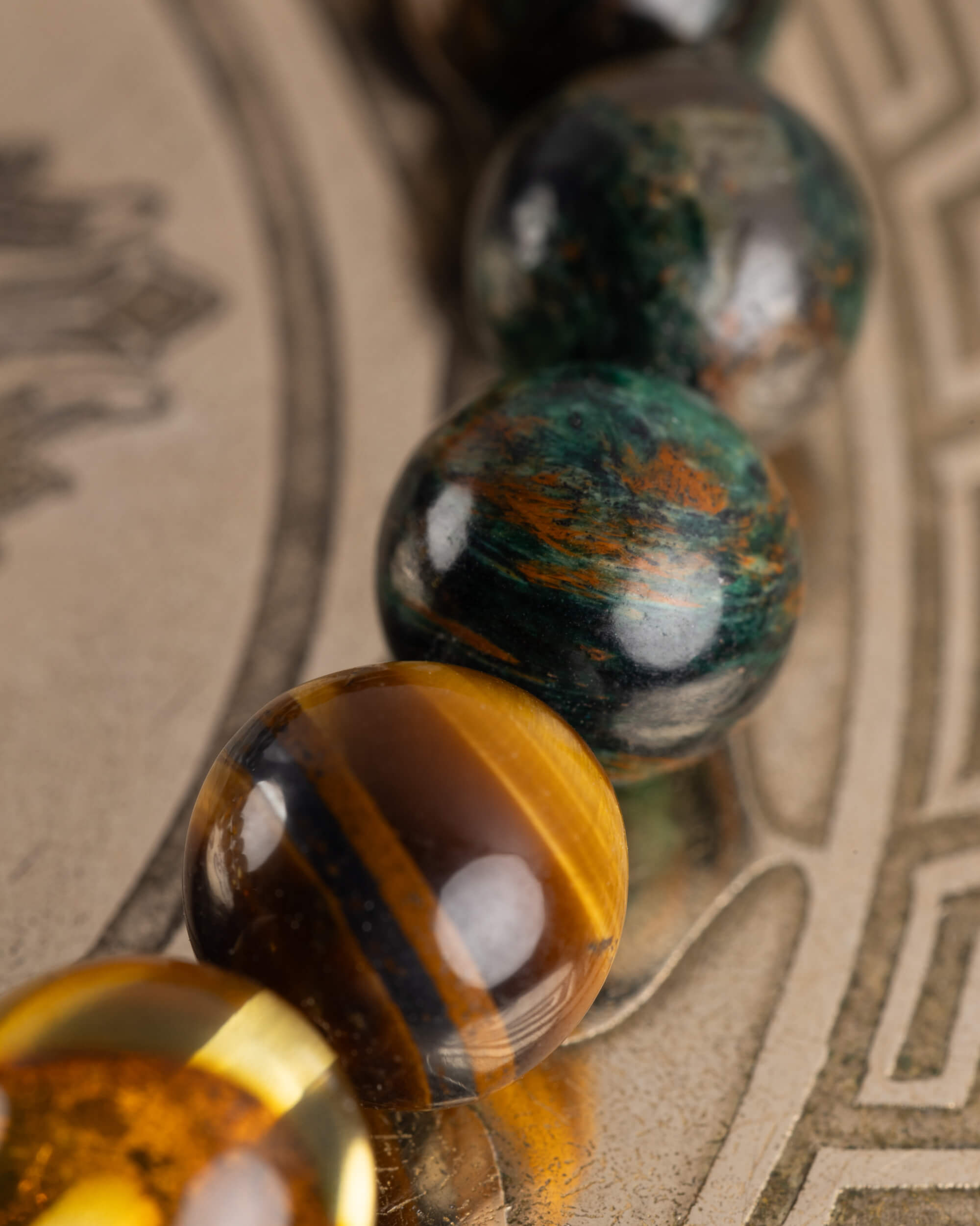 Detalle macro de las cuentas de Ojo de Tigre de la Pulsera Freyr sobre placa grabada