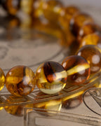 Detalle macro de las cuentas de Ámbar de la Pulsera Freyr sobre placa grabada