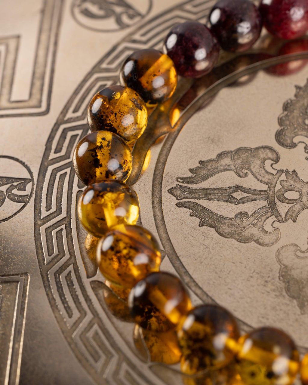 Detalle macro de las cuentas de Ámbar de la Pulsera Inti junto a granate oscuro