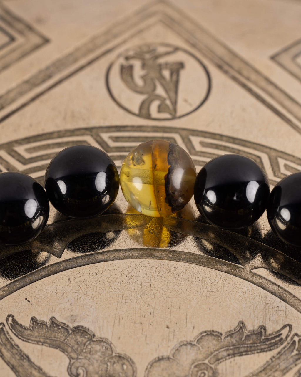 Detalle macro de una cuenta de Ámbar entre Turmalina Negra, pulsera Horus