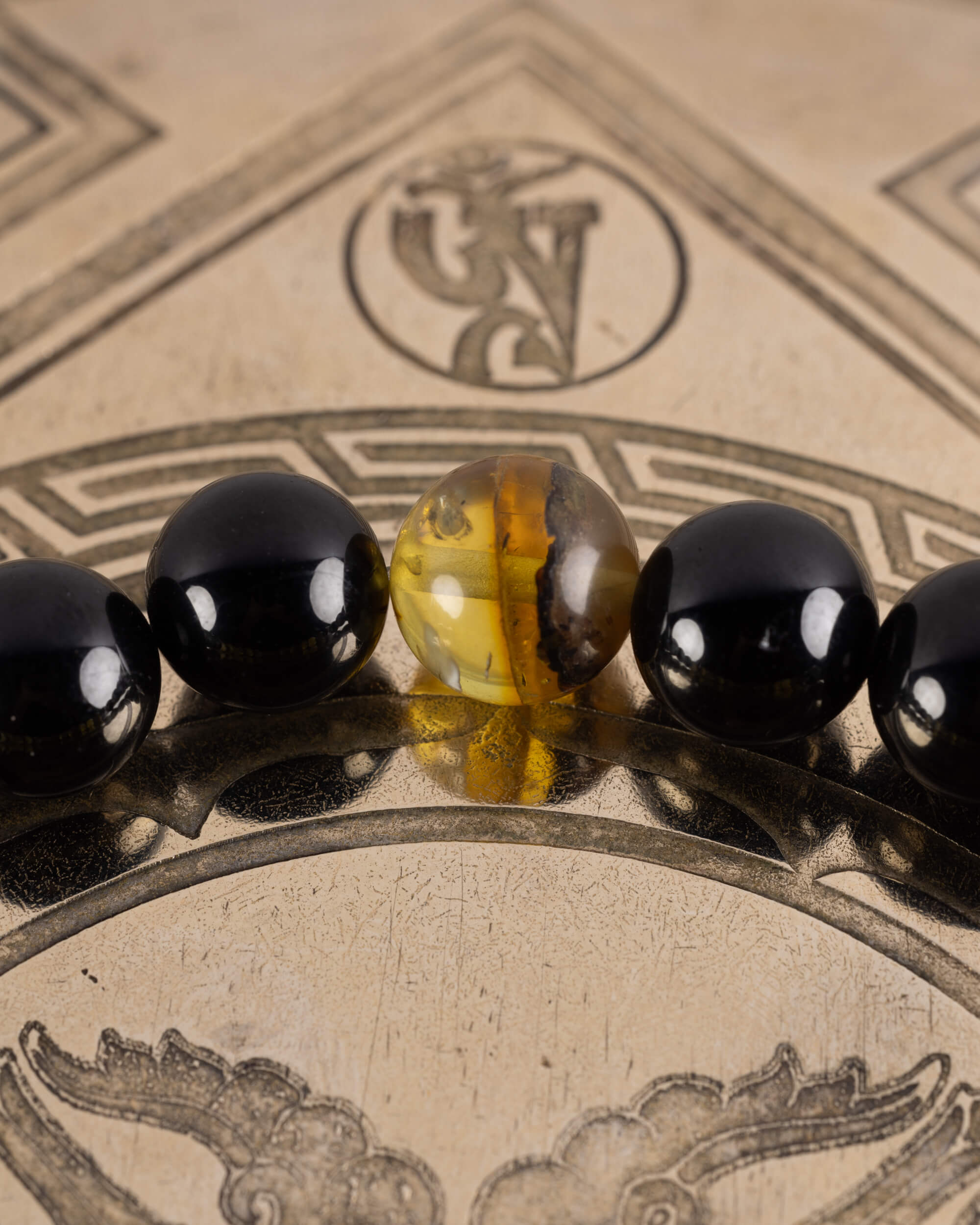 Detalle macro de una cuenta de Ámbar entre Turmalina Negra, pulsera Horus