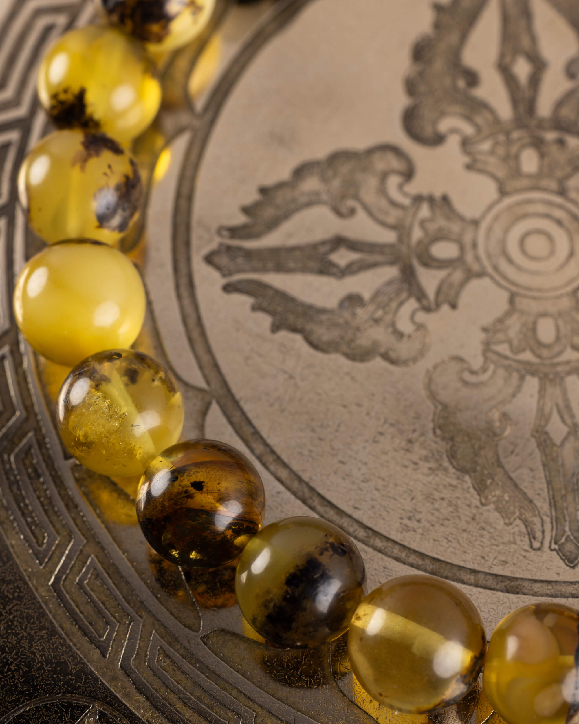 Detalle macro de cuentas de Ámbar en tonos miel y ambar oscuro, pulsera Horus