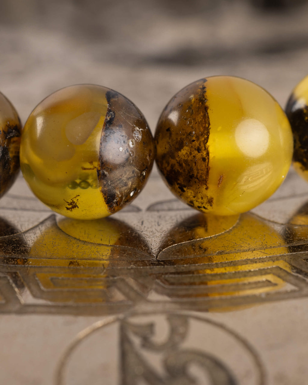 Detalle macro de cuentas de Ámbar con vetas oscuras, pulsera Horus