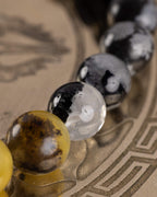 cuenta clara con mancha negra junto a cuentas grises moteadas, pulsera Horus