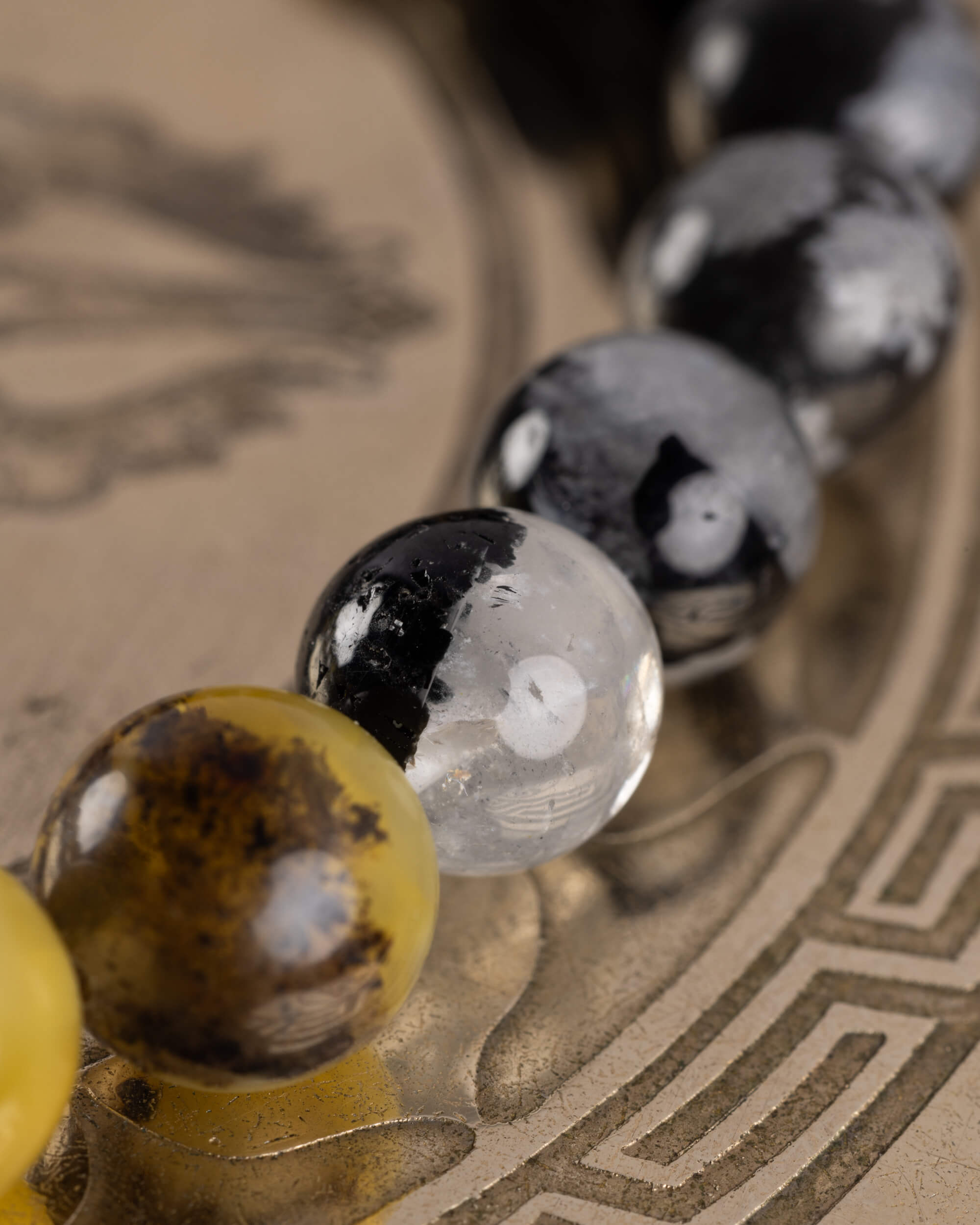 cuenta clara con mancha negra junto a cuentas grises moteadas, pulsera Horus