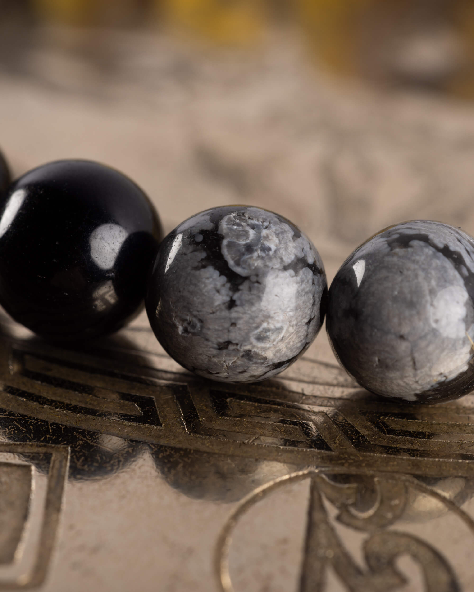 Detalle macro de Turmalina Negra entre cuentas de Obsidiana Copo de Nieve, pulsera Horus
