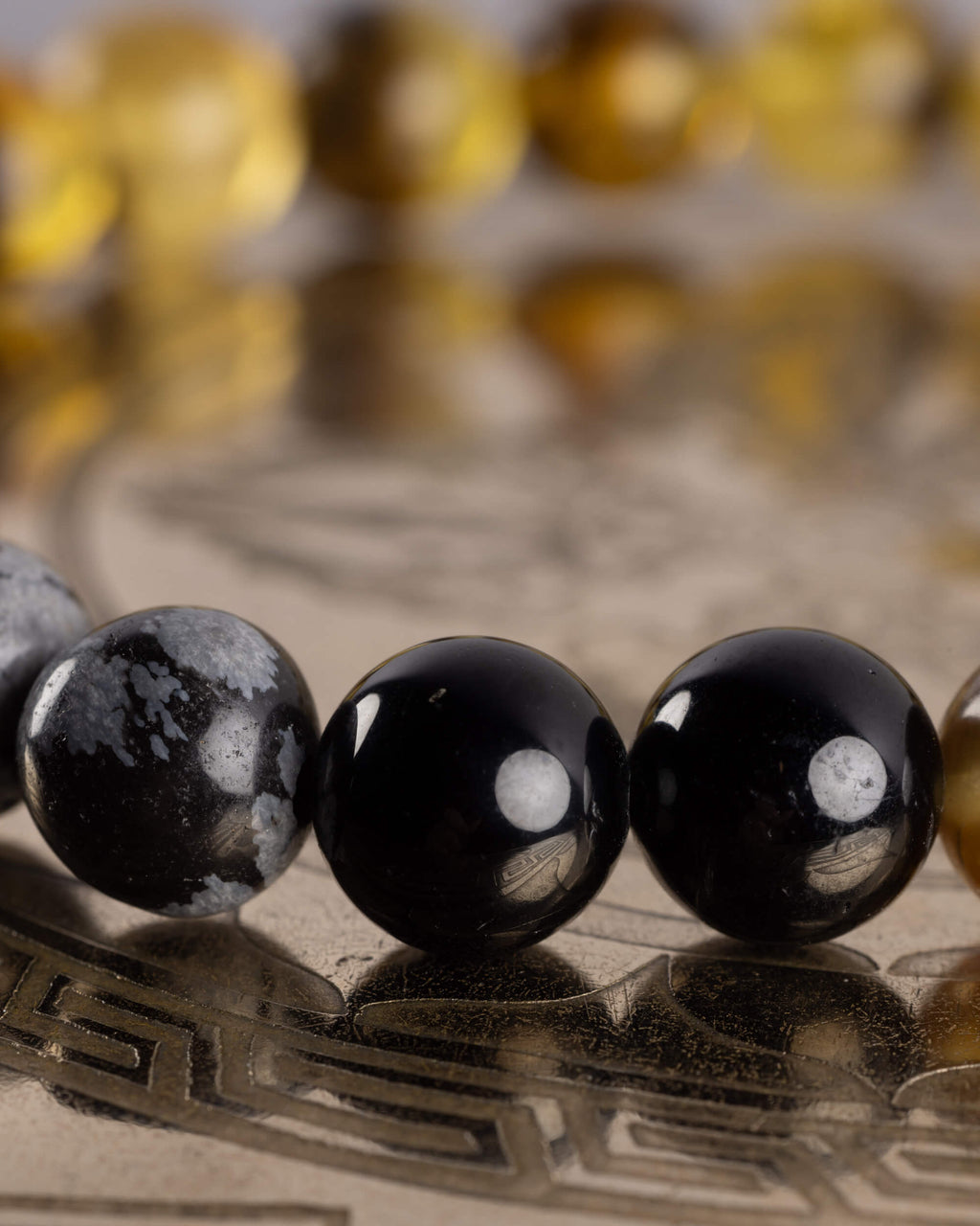 Detalle macro de Obsidiana Copo de Nieve junto a Turmalina Negra, pulsera Horus