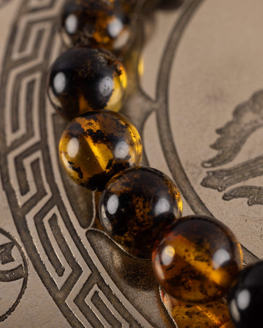 Detalle macro de cuentas de Ámbar y Obsidiana Caoba, pulsera Kinich Ahau