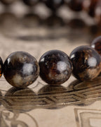 Detalle macro de cuentas de Flogopita con vetas claras, pulsera Kinich Ahau