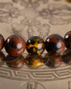 Detalle macro de cuentas de Obsidiana Caoba y Ámbar, pulsera Kinich Ahau