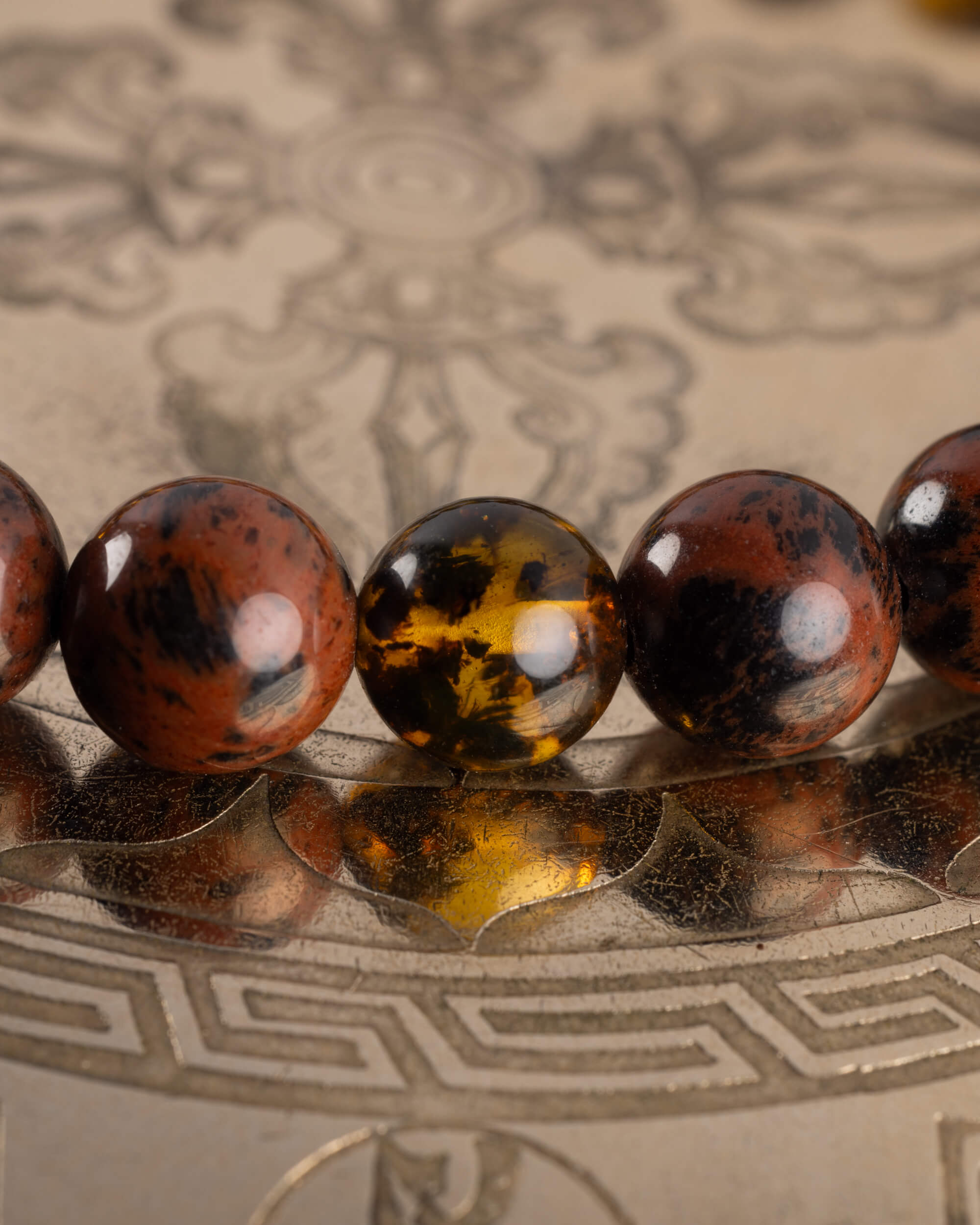 Detalle macro de cuentas de Obsidiana Caoba y Ámbar, pulsera Kinich Ahau