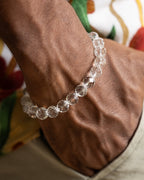 Pulsera de Cuarzo Transparente puesta en la muñeca, cuentas facetadas a la luz