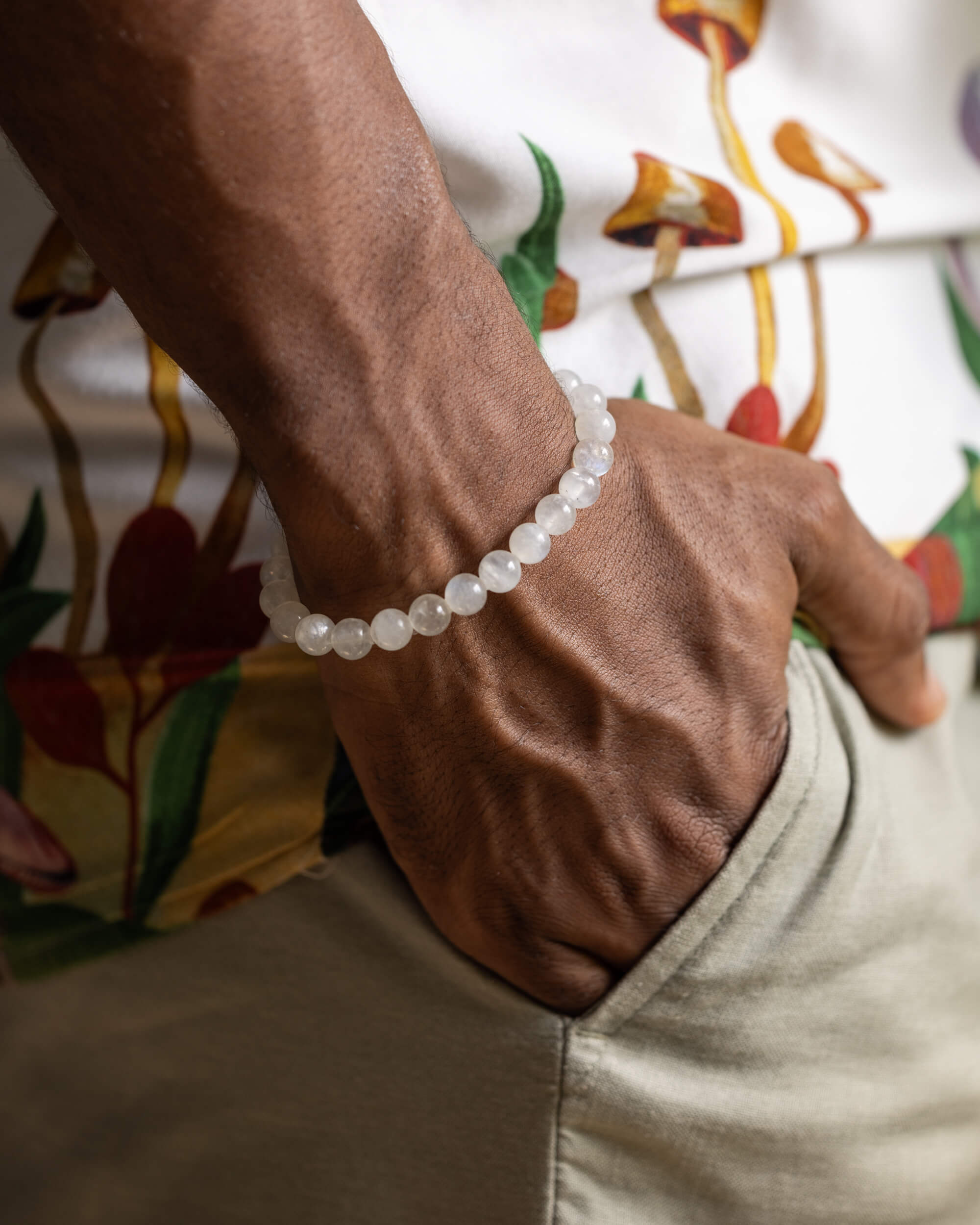Pulsera de Piedra Luna puesta en la muñeca, mano descansando junto al bolsillo