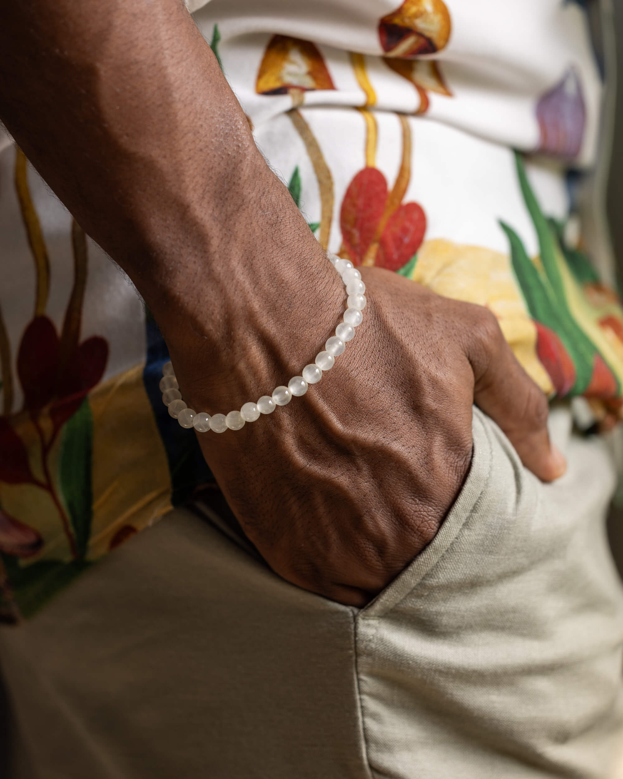 Pulsera de Selenita puesta en la muñeca junto a pantalón caqui