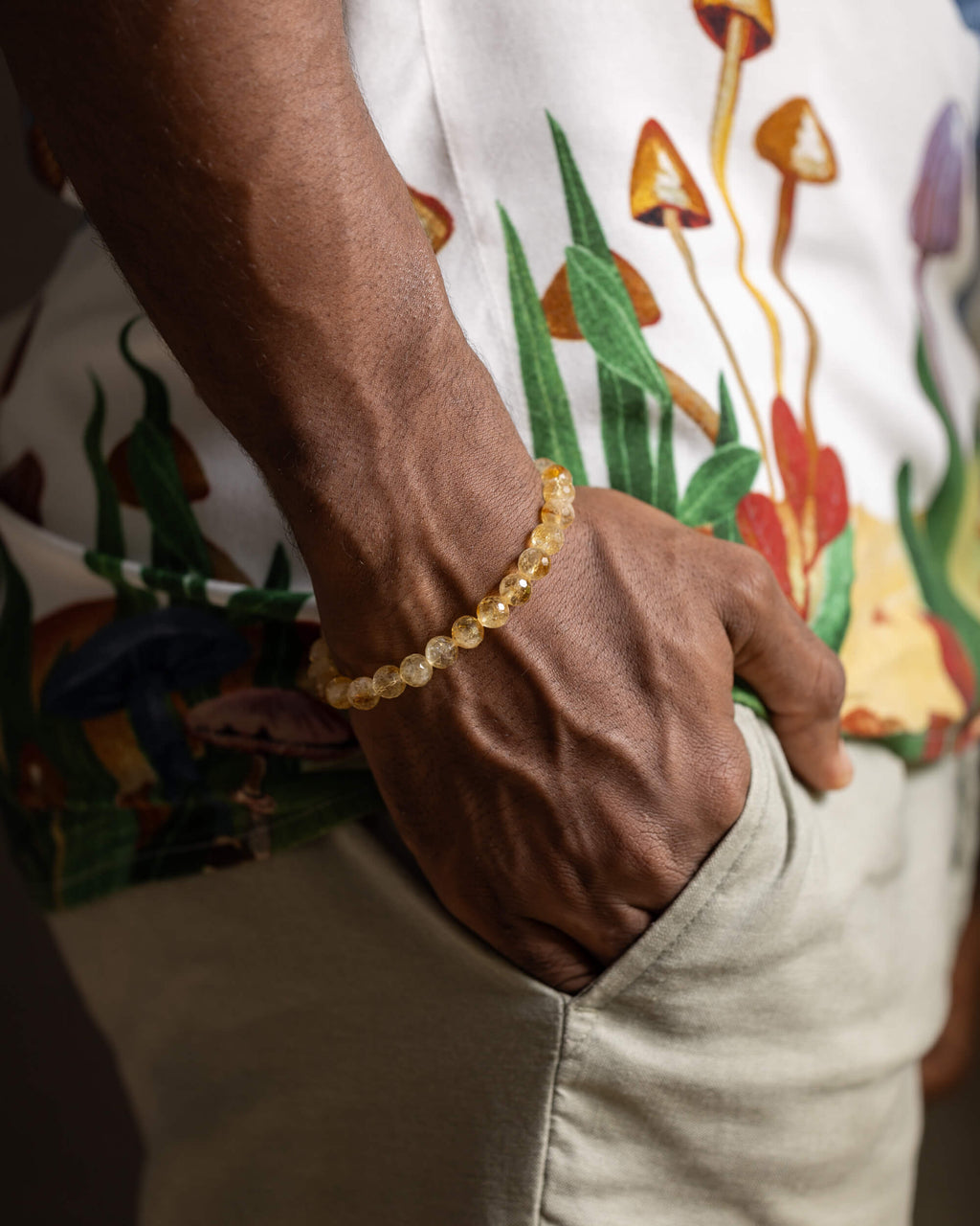 Pulsera de Citrino puesta en la muñeca, mano descansando junto al bolsillo