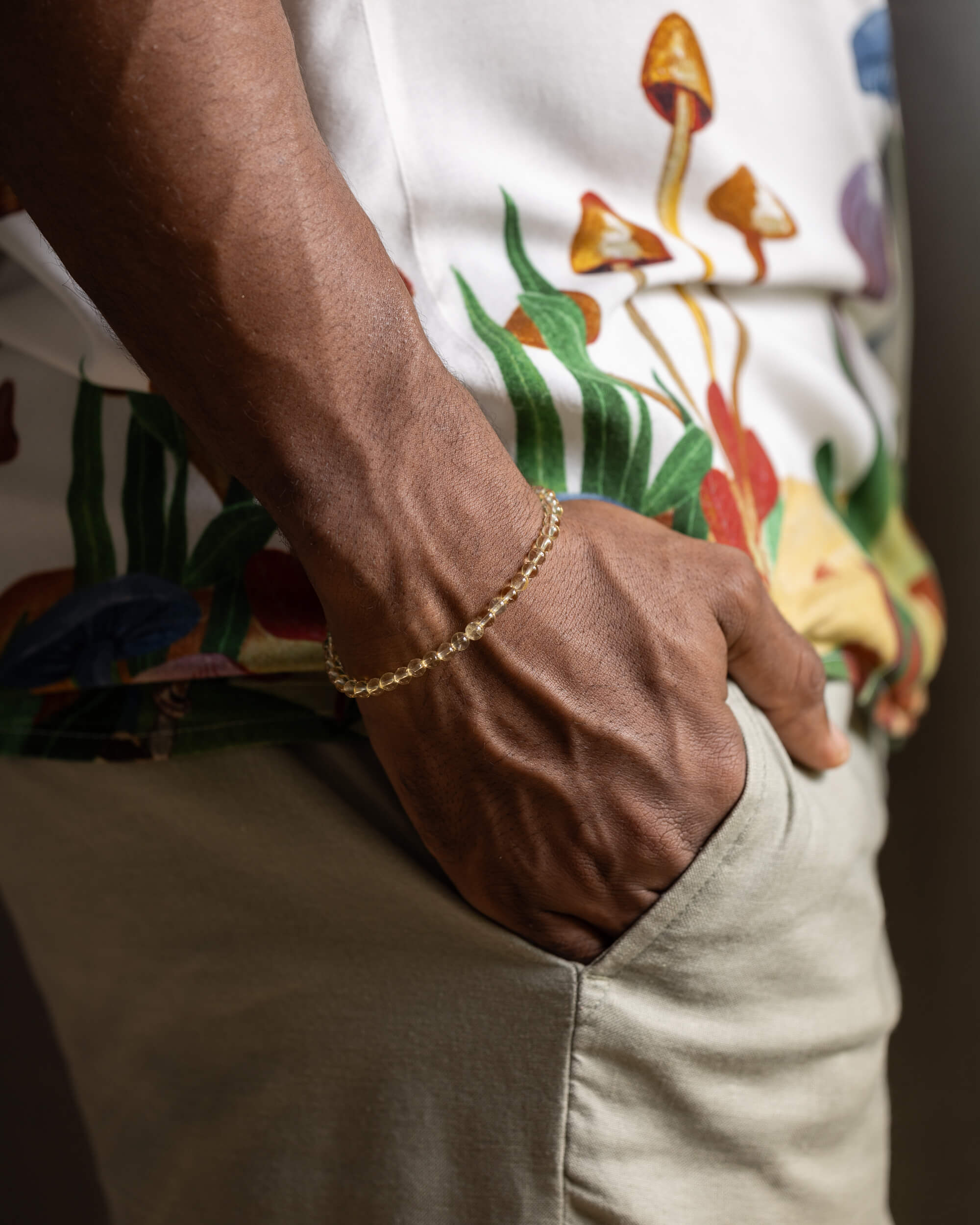 Pulsera de Citrino puesta en la muñeca, detalle de la mano en el bolsillo