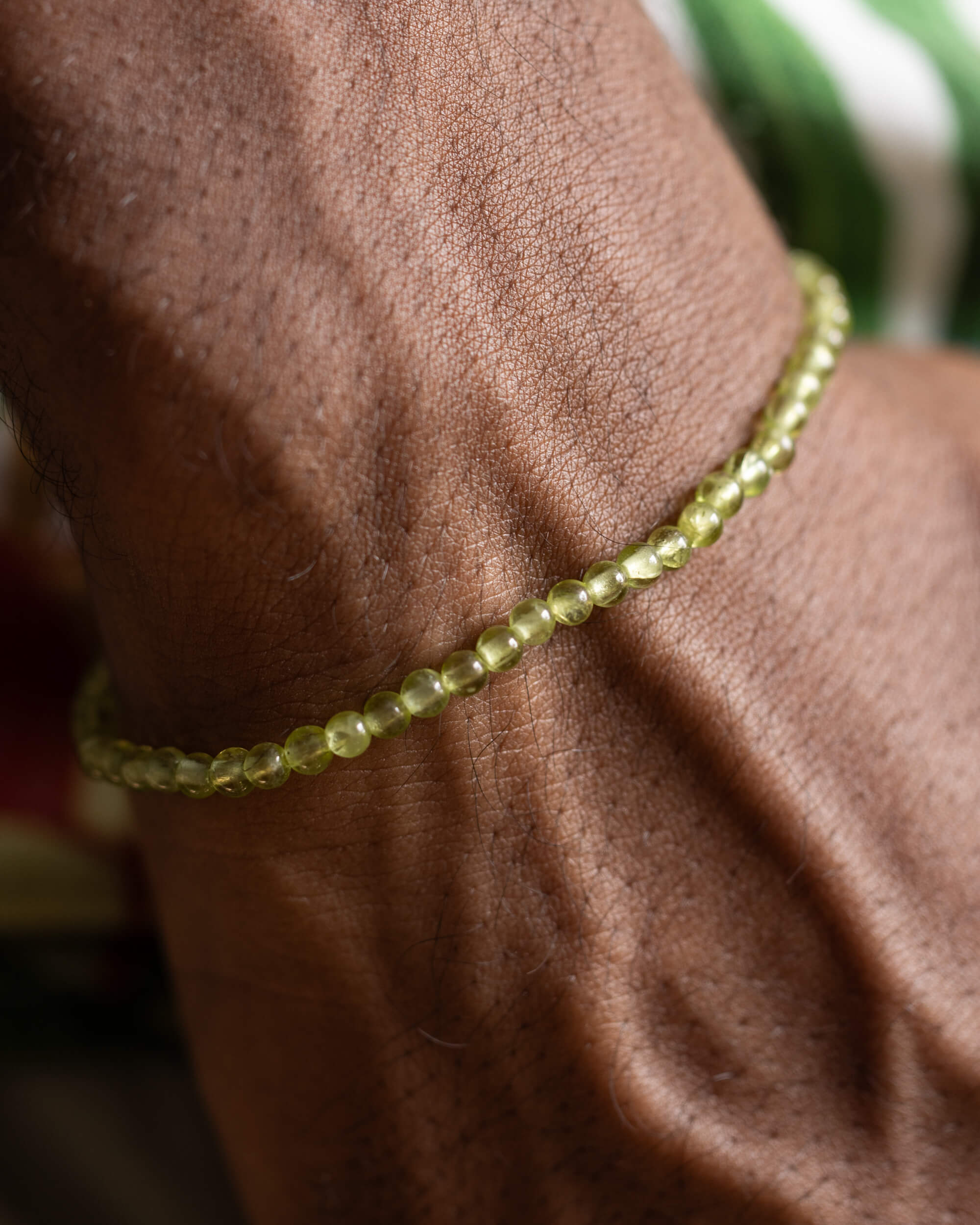 Pulsera de Peridoto puesta en la muñeca, vista de las cuentas verdes