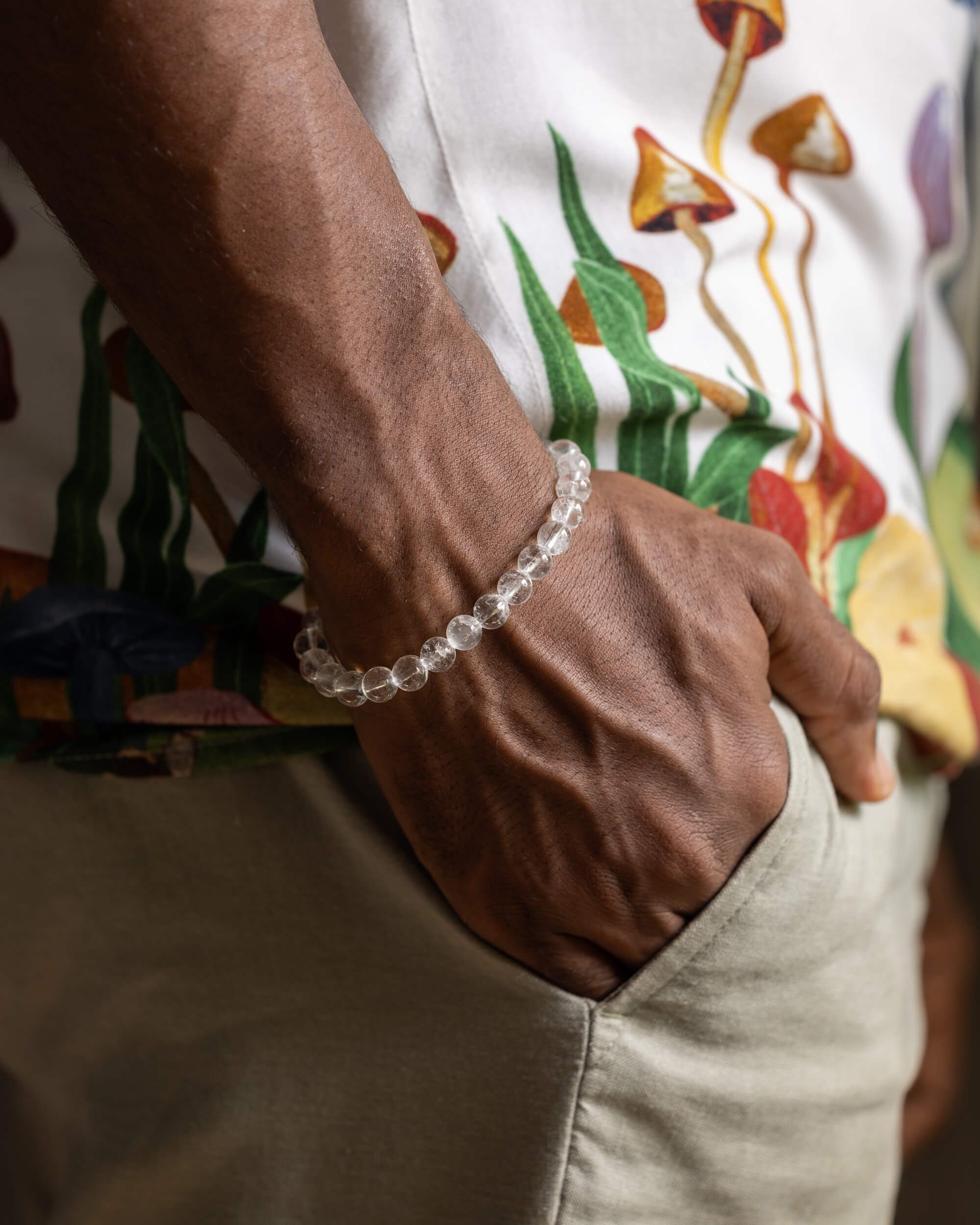 Pulsera de Cuarzo Transparente puesta en la muñeca sobre pantalon claro