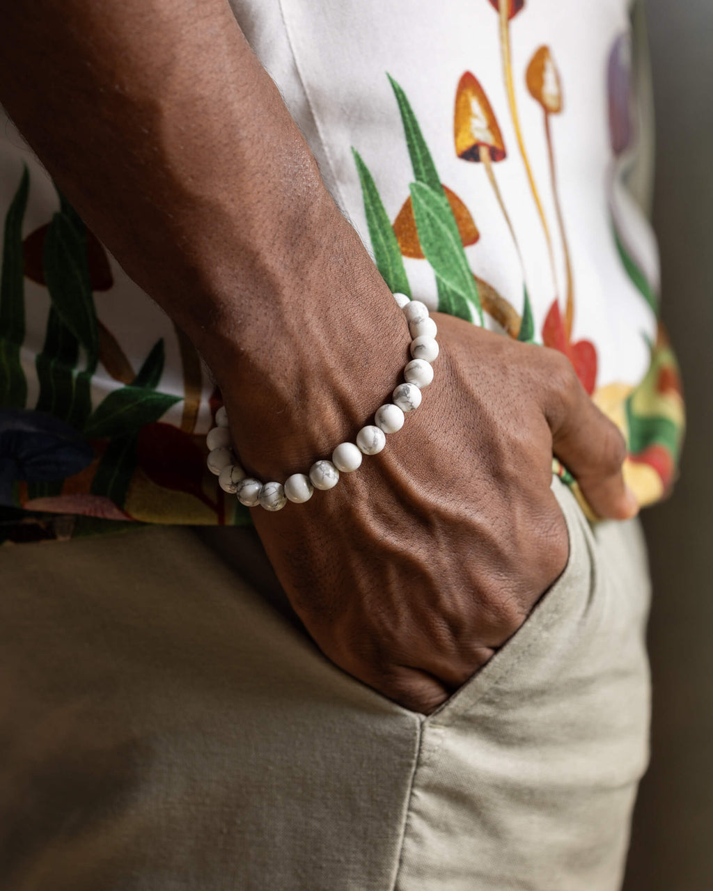 Pulsera de Howlita puesta en muñeca, vetas grises sobre blanco