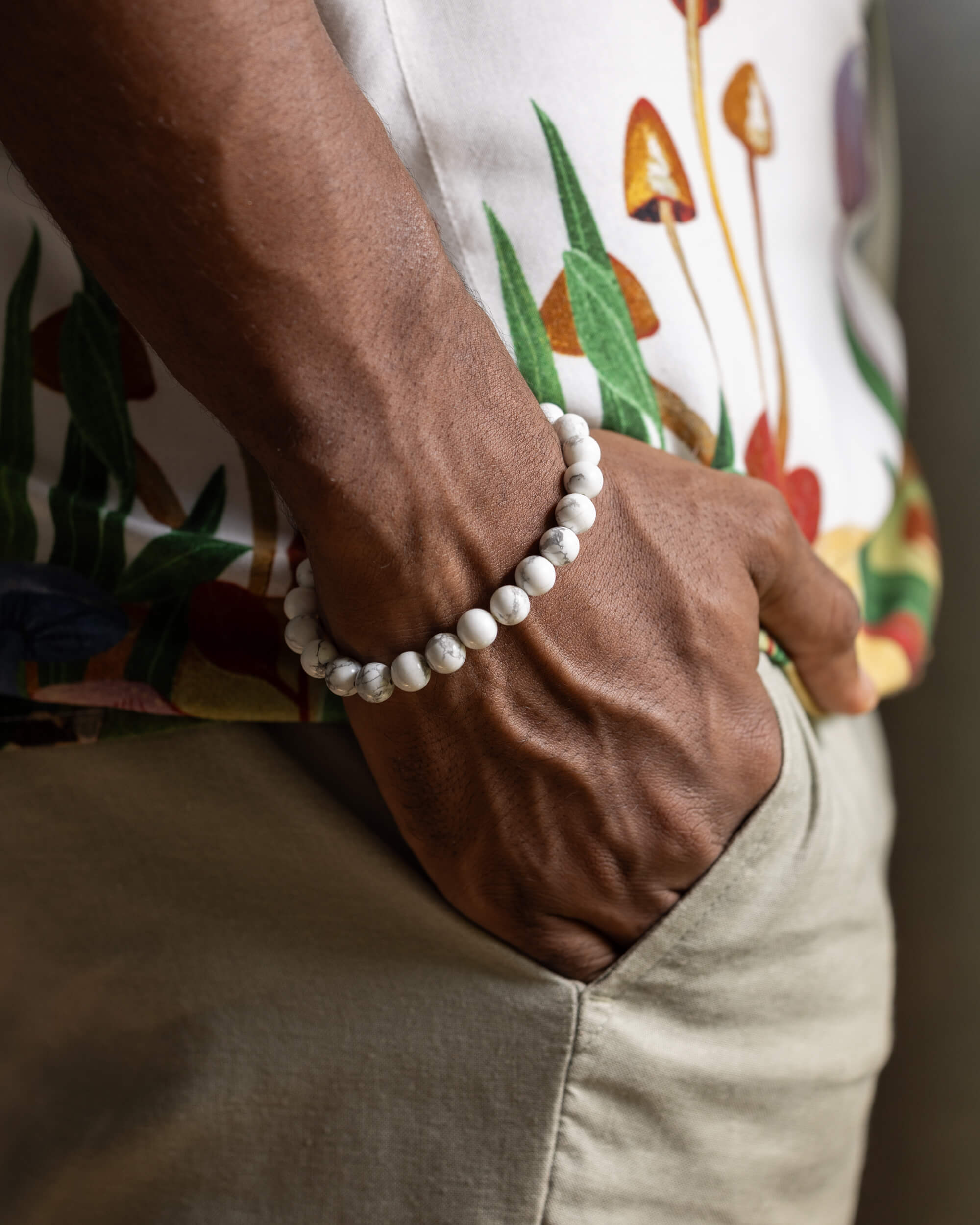 Pulsera de Howlita puesta en muñeca, vetas grises sobre blanco