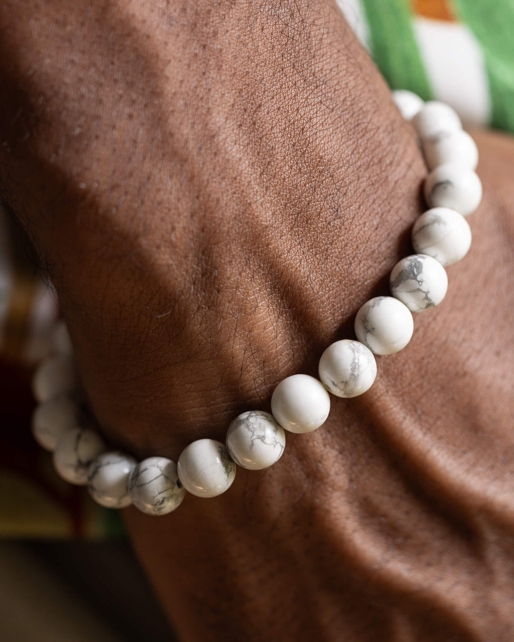 Pulsera de Howlita puesta en muñeca, textura blanca veteada de gris