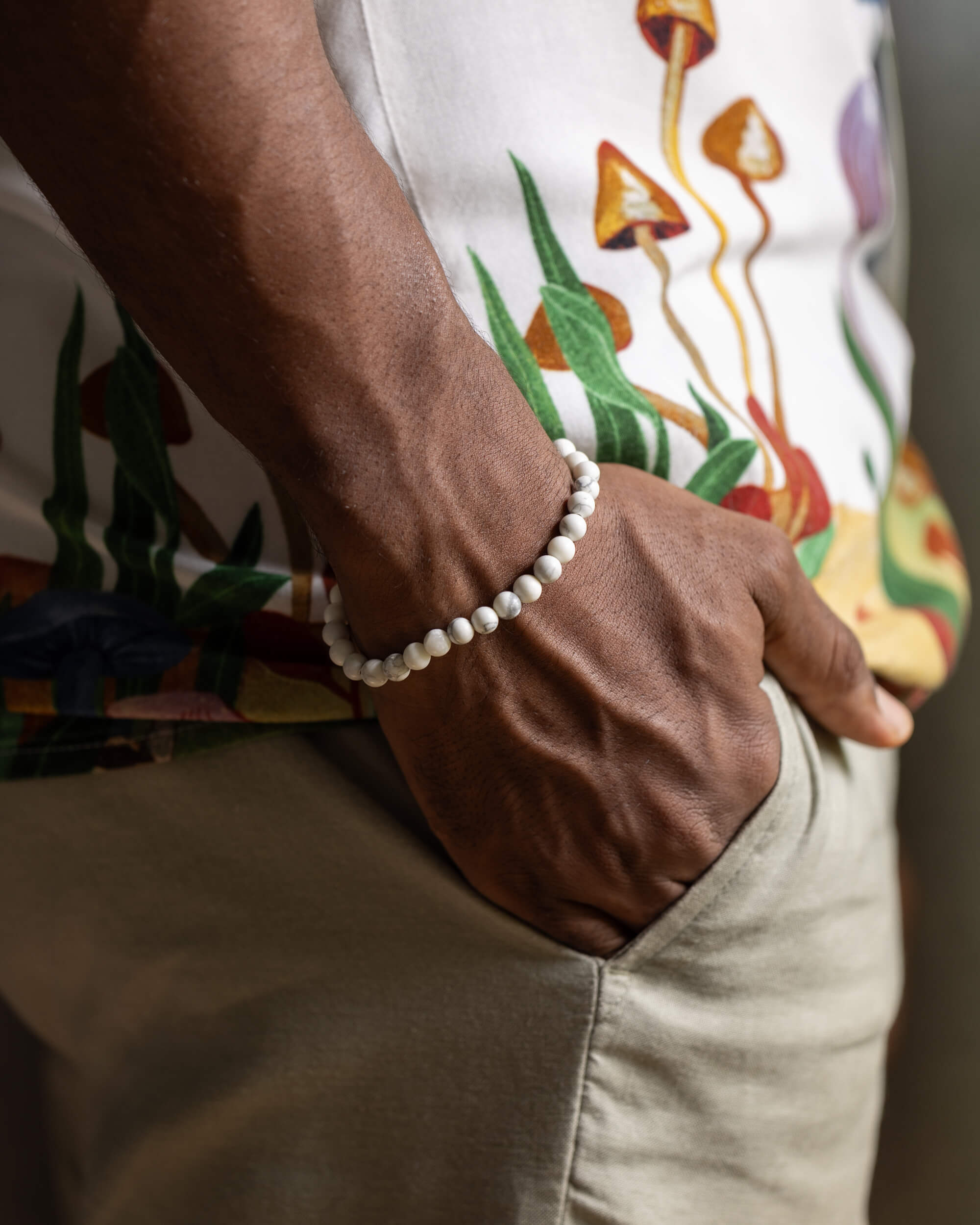 Pulsera de Howlita puesta en la muñeca junto a pantalón caqui