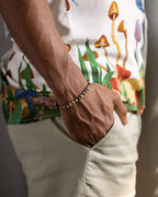 Pulsera de Jaspe Oceánico Amarillo puesta en la muñeca, mano en el bolsillo