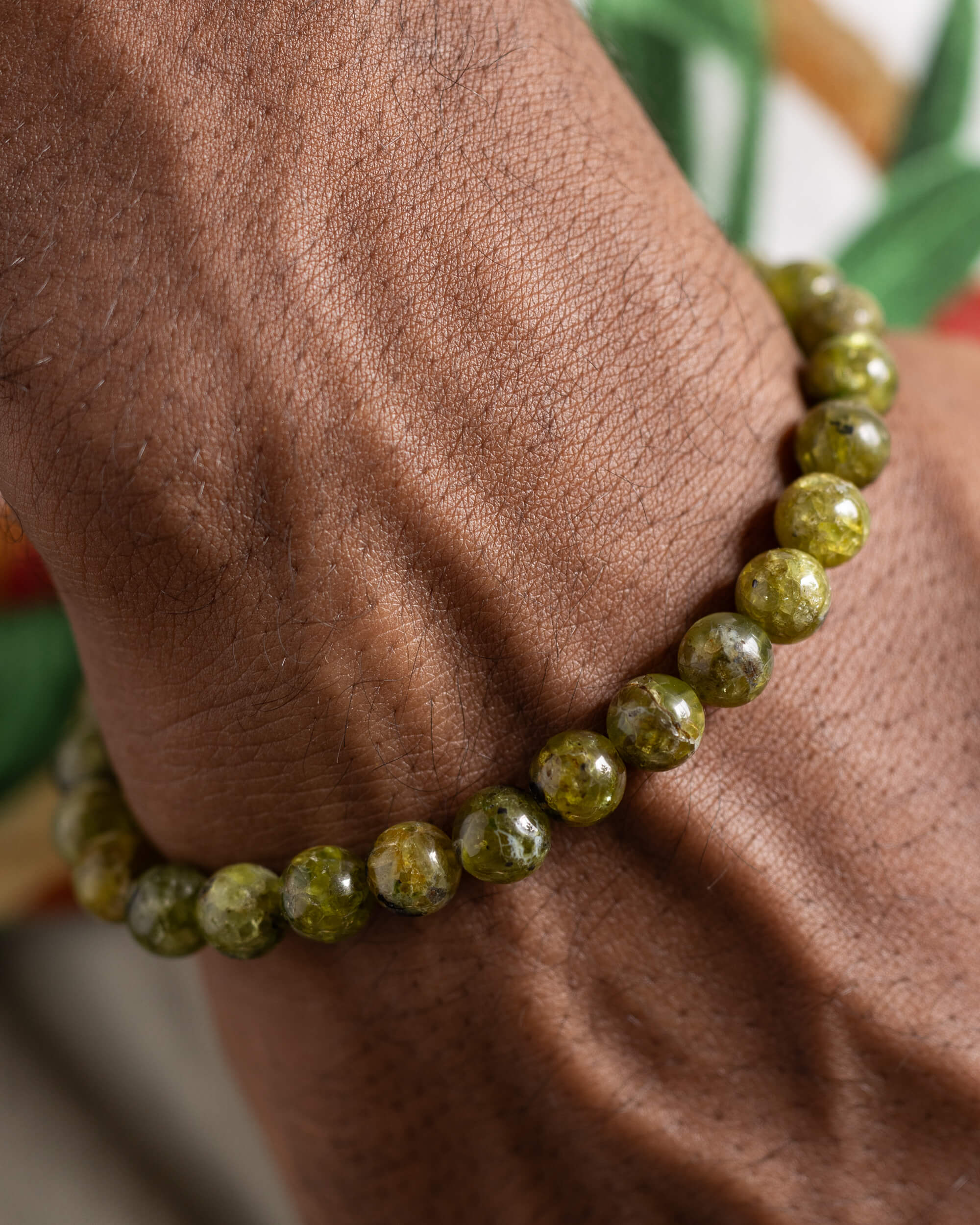 Pulsera de Peridoto puesta en la muñeca, vista cercana de las cuentas