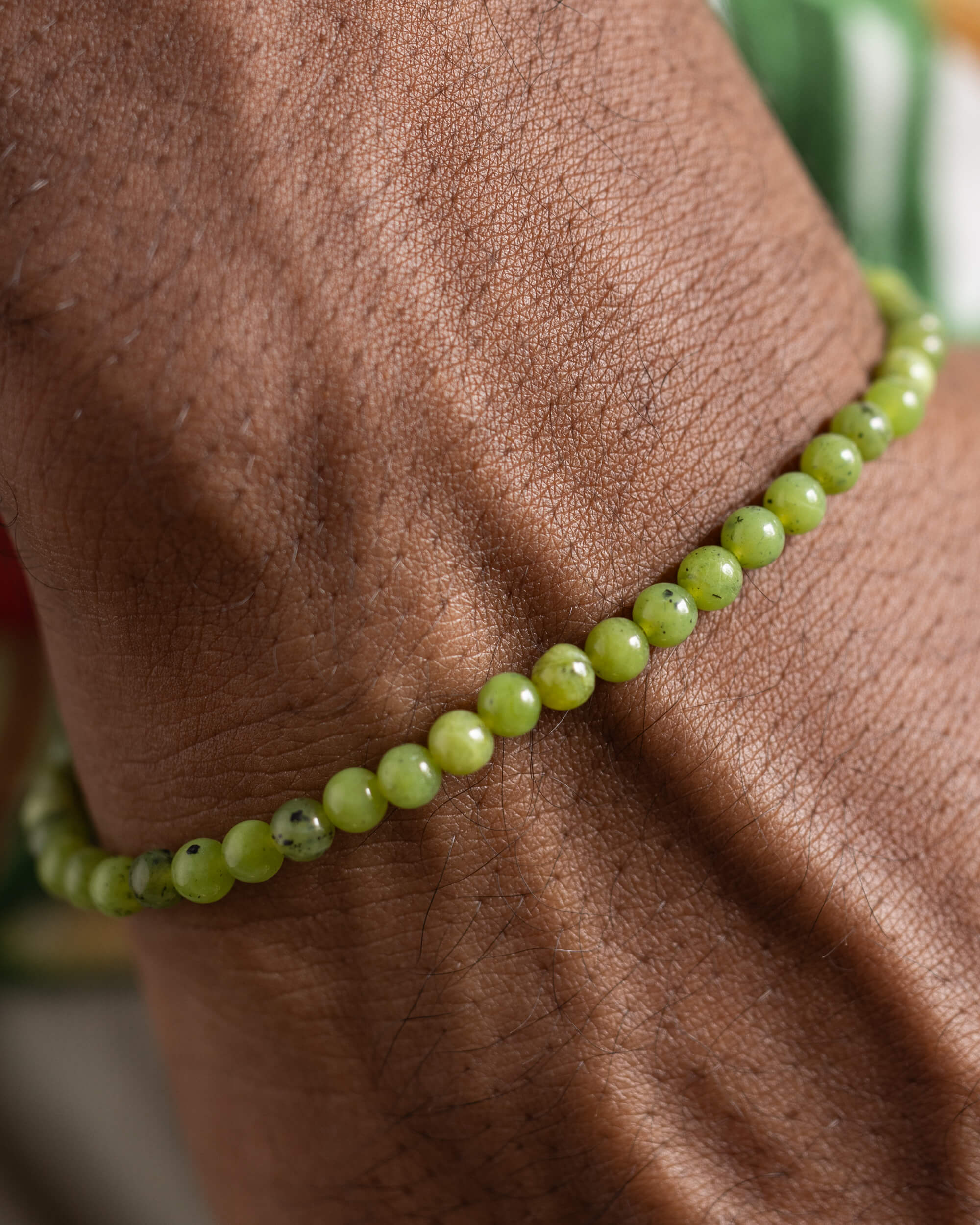 Pulsera de Jade Verde puesta en la muñeca, detalle cercano de las cuentas sobre la piel
