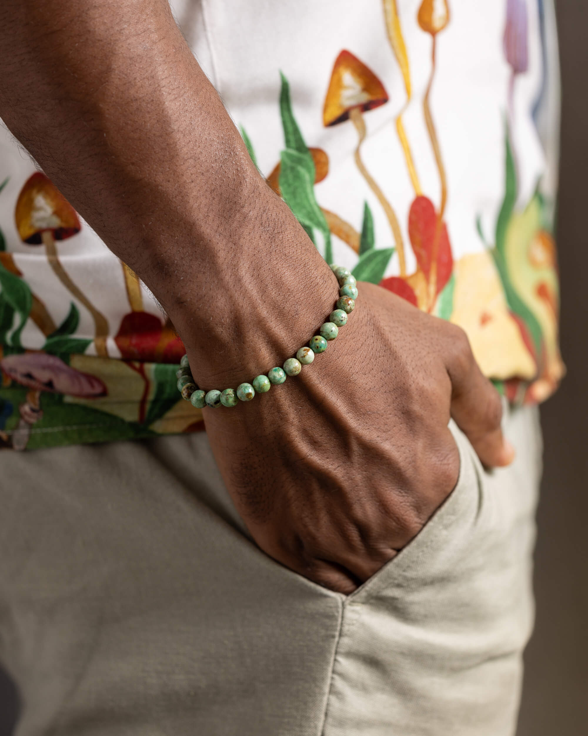 Pulsera de Turquesa Africana puesta en la muñeca, con la mano en el bolsillo