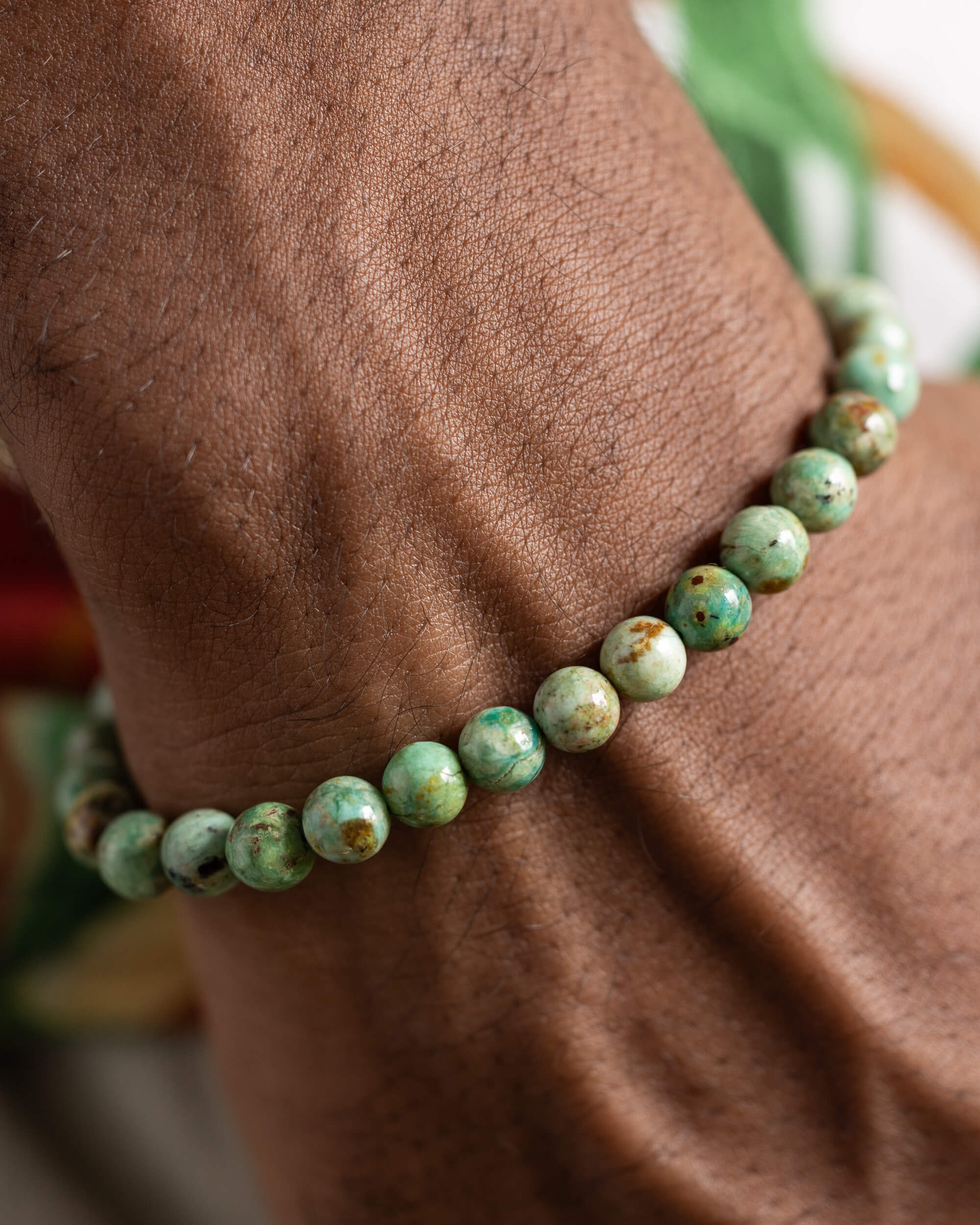 Pulsera de Turquesa Africana puesta en la muñeca sobre estampado floral