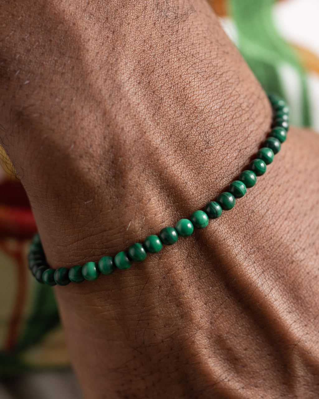 Pulsera de Malaquita puesta en la muñeca, detalle cercano de las cuentas verdes