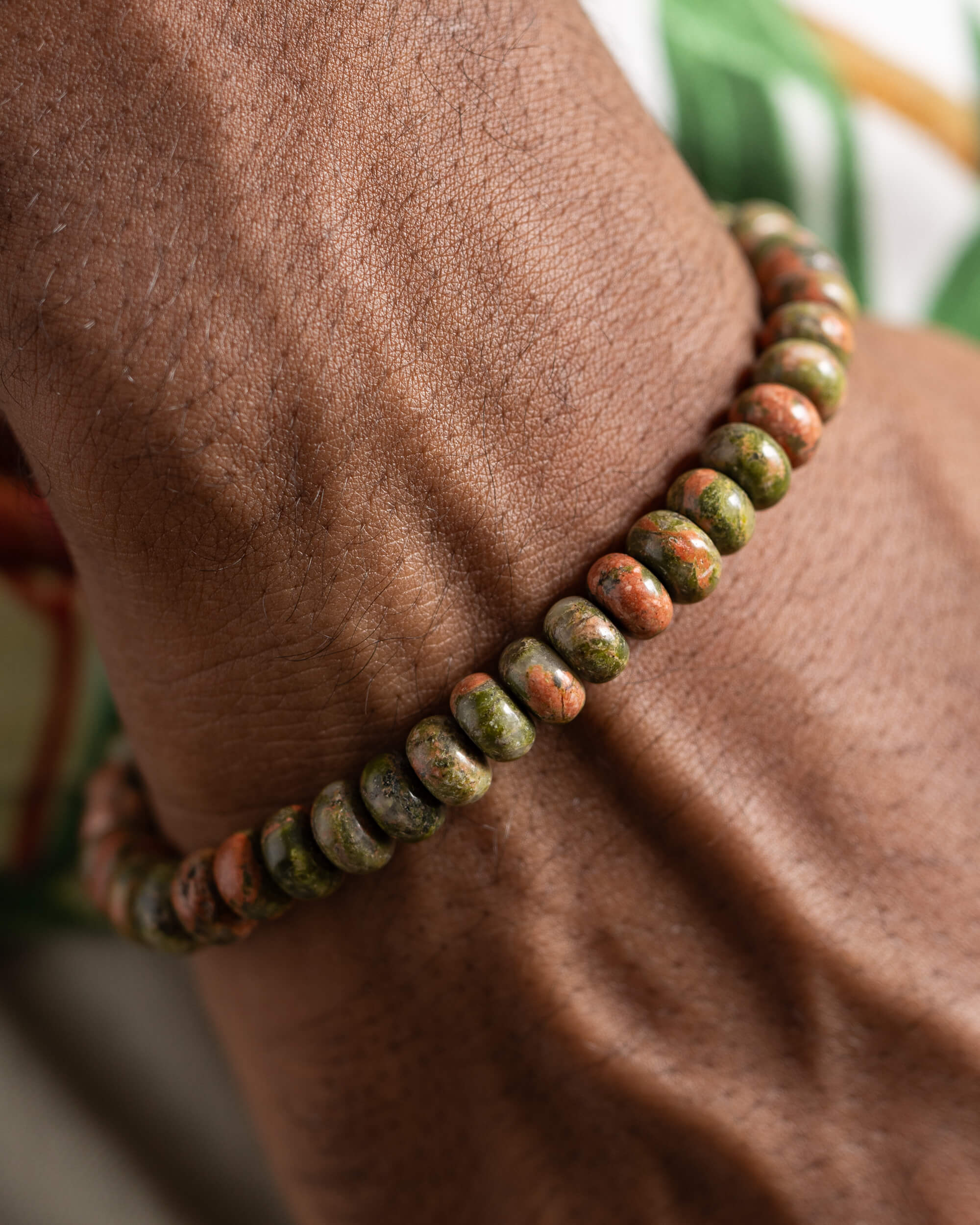 Pulsera de Jaspe Unakita puesta en la muñeca, vista cercana de las cuentas
