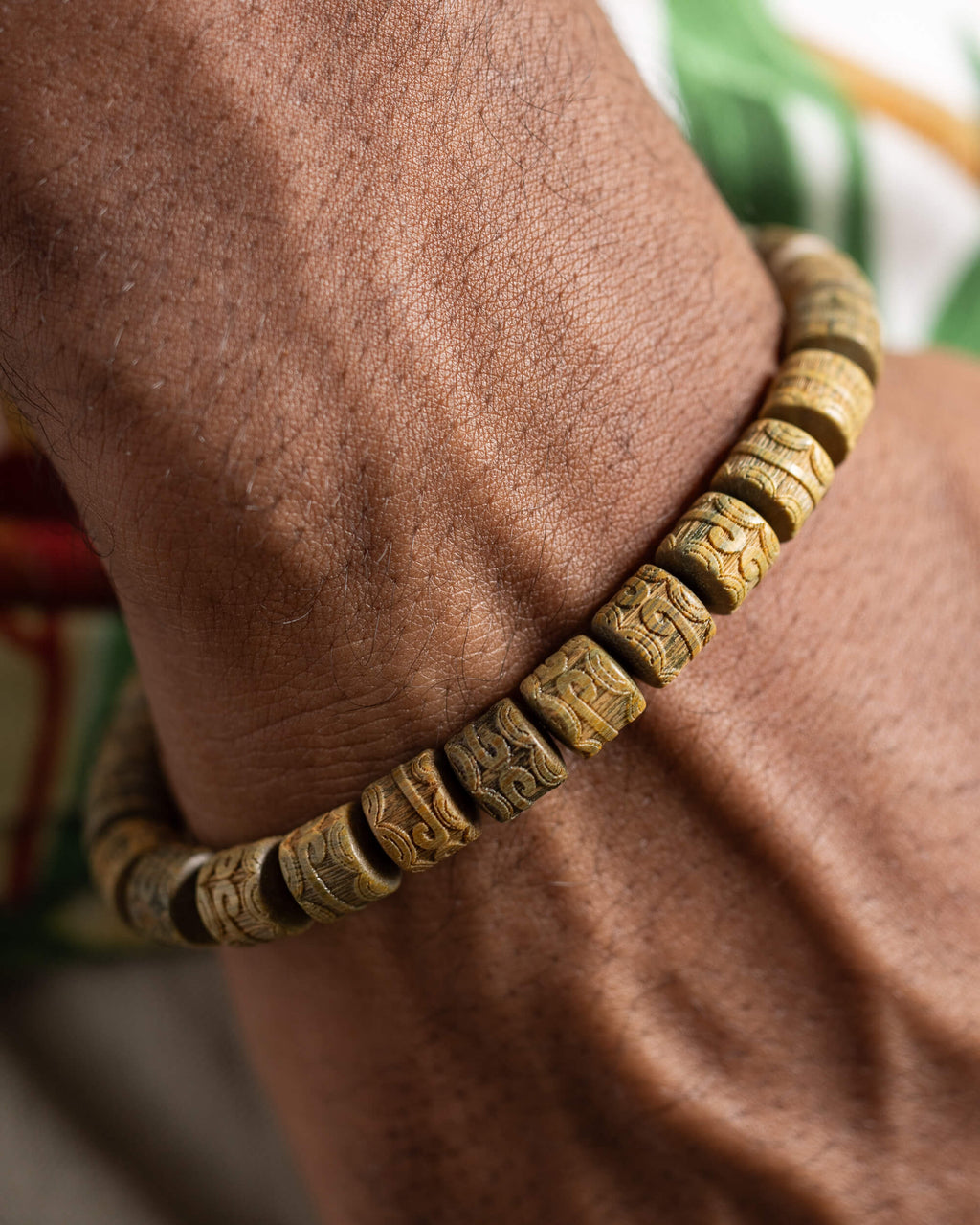 Pulsera de Madera de Sándalo puesta en la muñeca, detalle cercano de las cuentas talladas