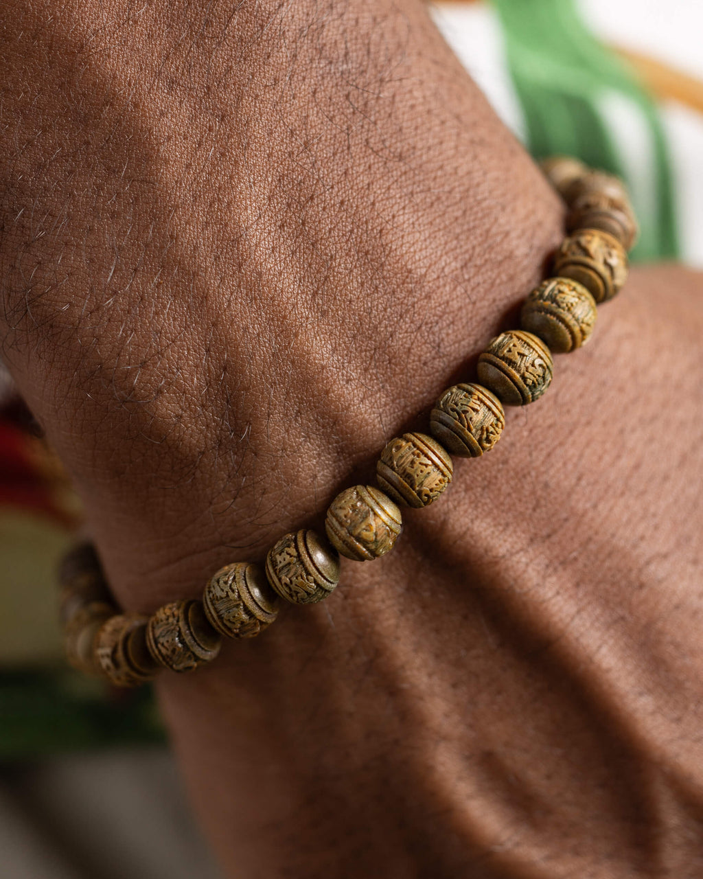 Pulsera de Madera de Sándalo tallada puesta, acercamiento a las cuentas sobre la muñeca