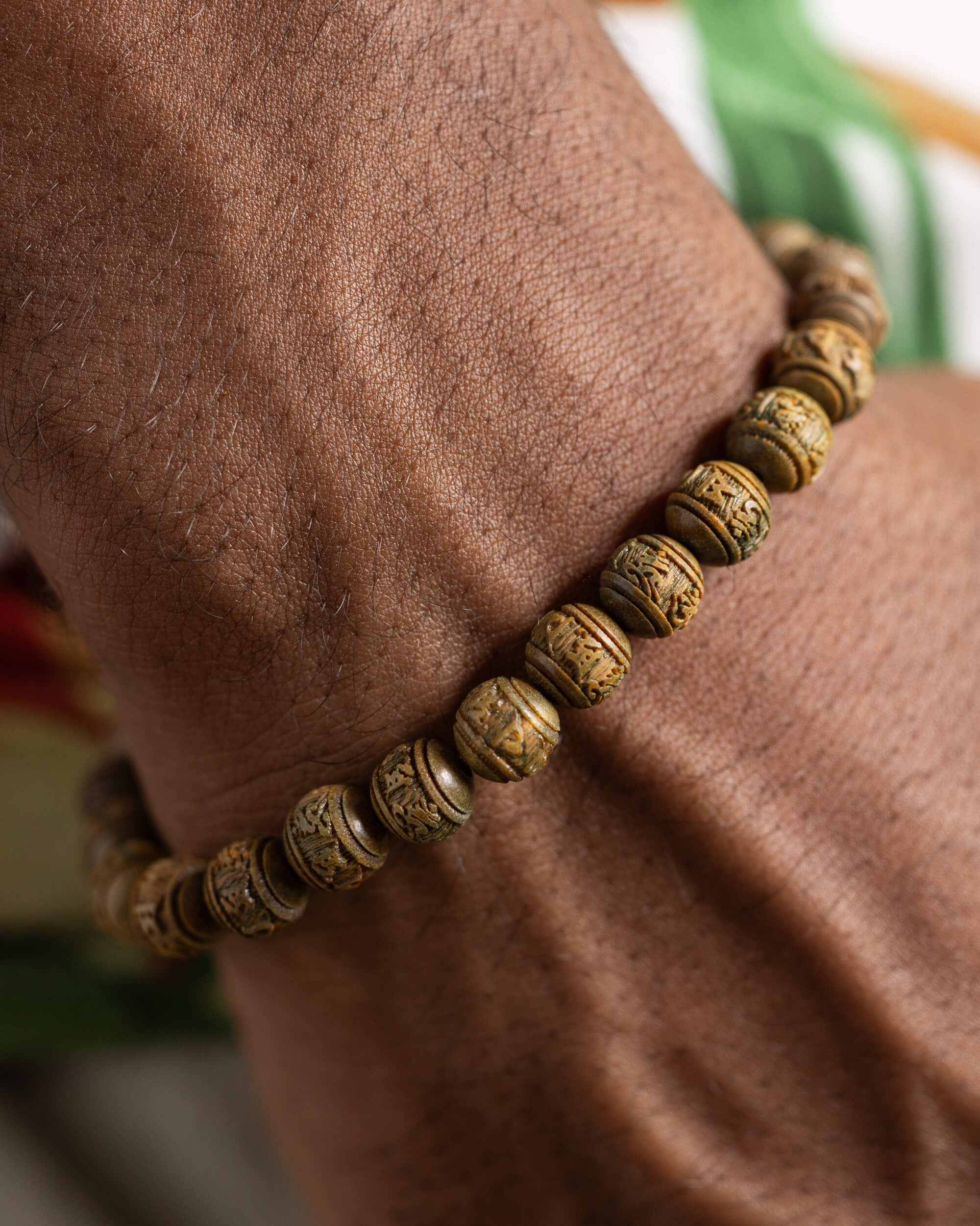 Pulsera de Madera de Sándalo tallada puesta, acercamiento a las cuentas sobre la muñeca